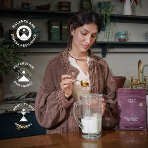 Woman preparing a protein shake with a package of Brave Ancestral Protein powder in a kitchen setting.