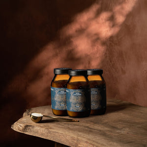 Three jars of ‘Wild Collagen' on a wooden surface with a warm brown background